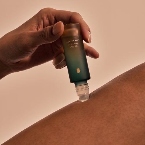 Revive Exta Serum roll-on applicator being used on the thighs with wooden cap massager alongside