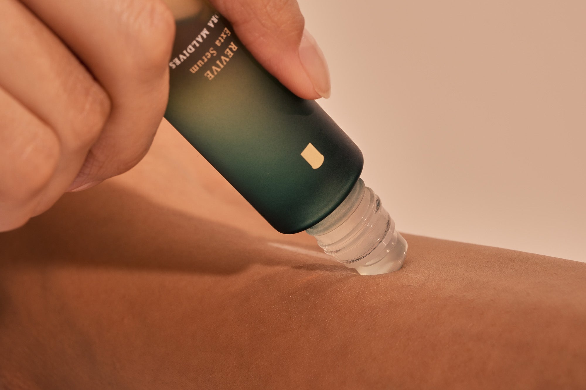 Close-up of cooling serum roller on the back of neck — cooling serum moment, skin contact, sensual angle