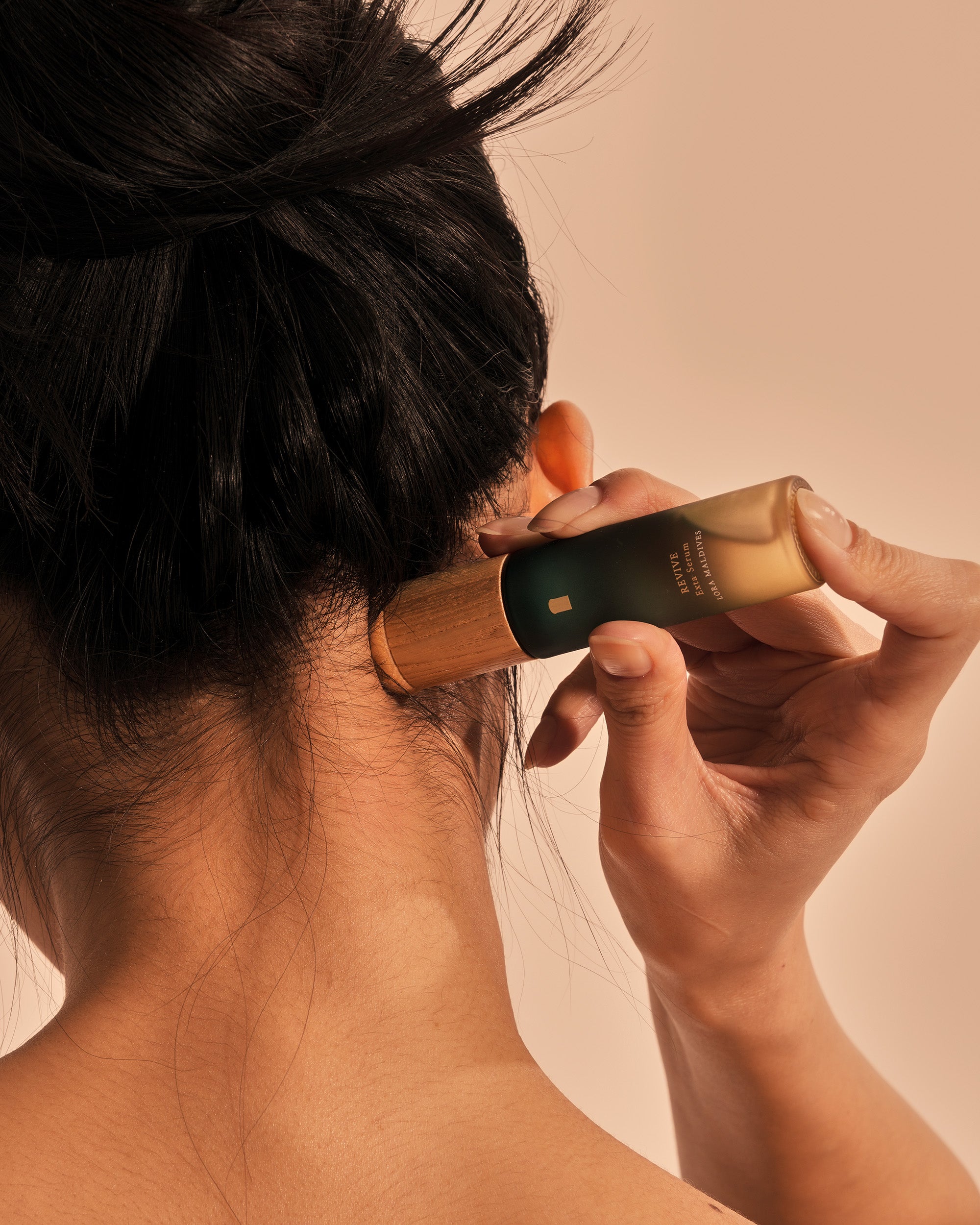 Lifestyle shot — massaging behind ear with woodcap, daily care moment, natural and intimate