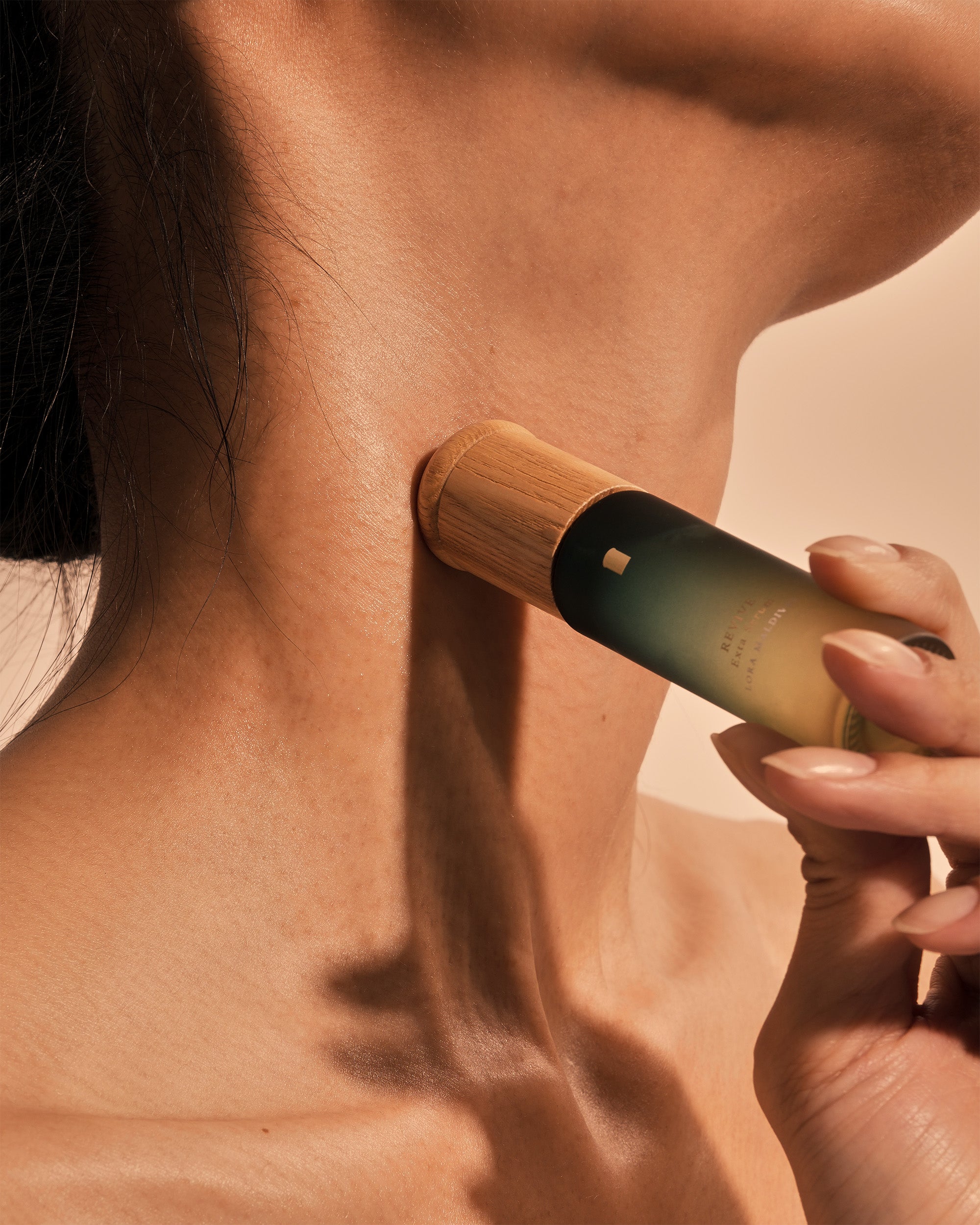 Close-up of woodcap massager on neck — ash wood grain visible, gentle massage along neck line